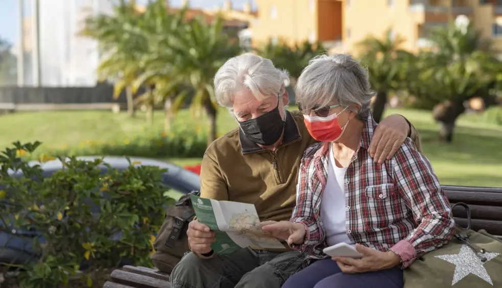 senior traveler couple consults a map