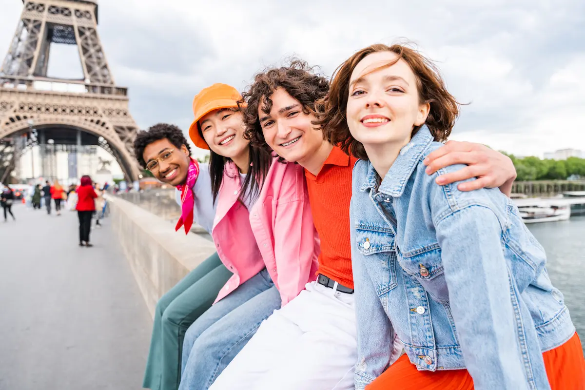 Group of young happy friends visiting Paris and Eiffel Tower