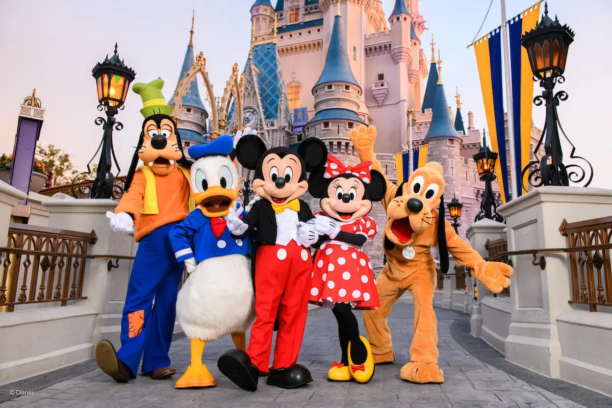 Goofy, Donald, Mickey, Miney and Pluto in front of the castle on a Disney school tour