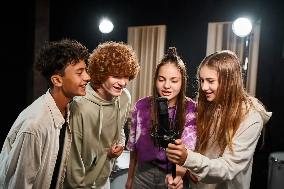 student singers recording in a booth