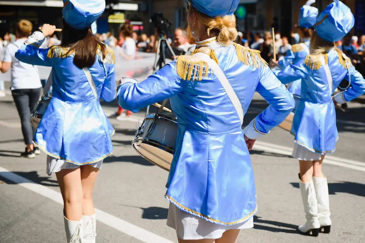 majorettes with white and blue uniforms perform on performance tours